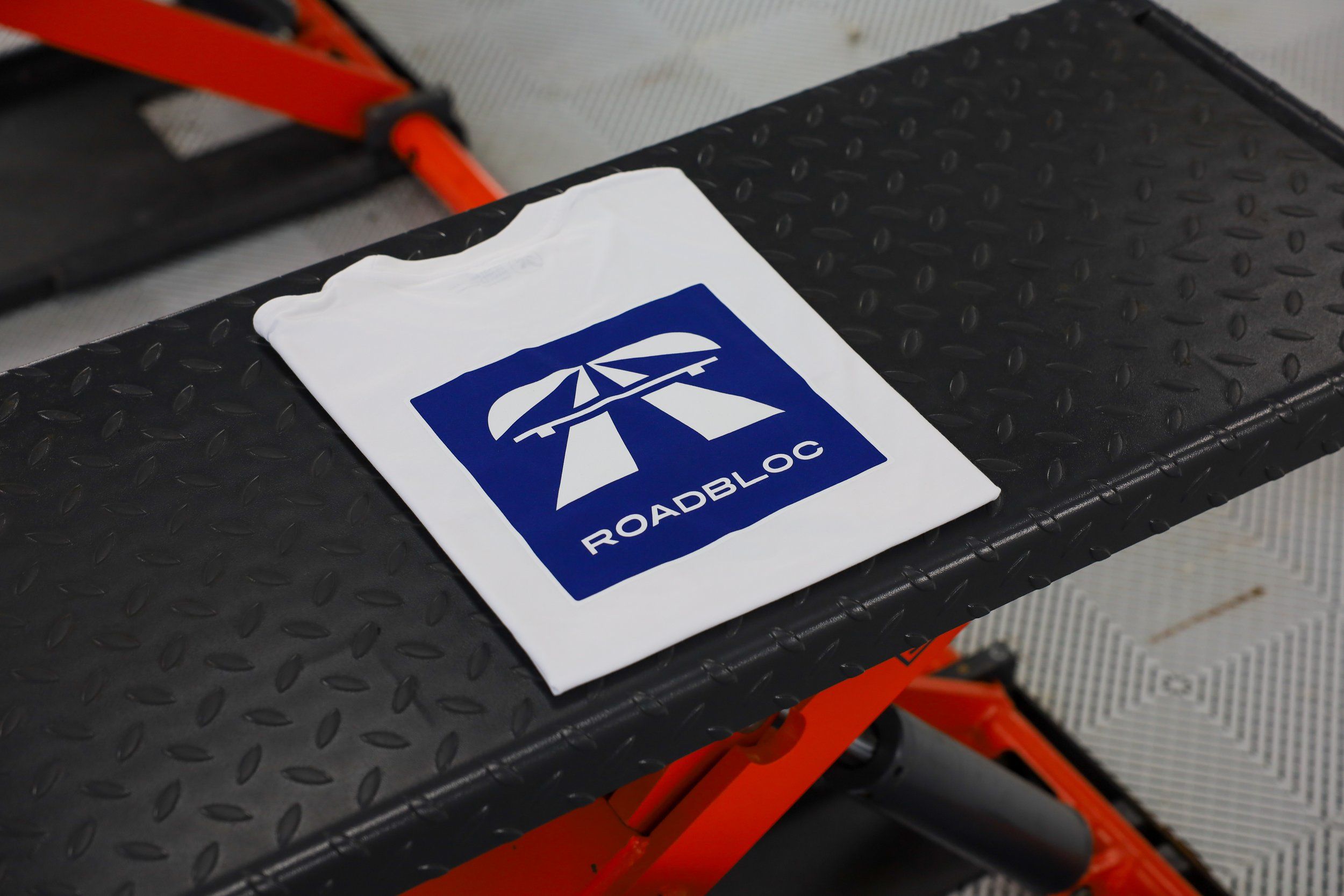 The Autobahn Tee by Roadbloc, white with the blue road sign graphic