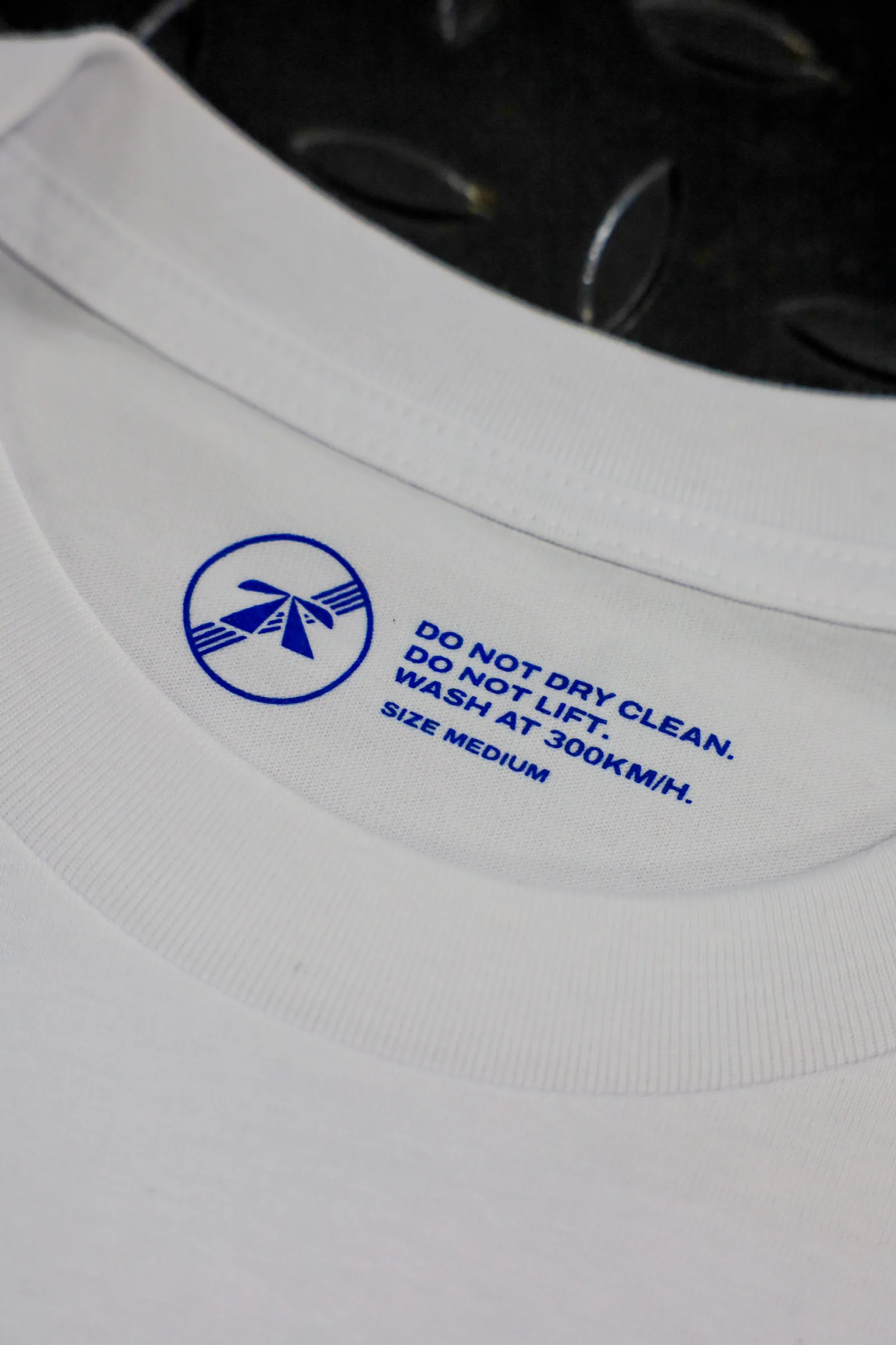 The Autobahn Tee by Roadbloc, white with the blue road sign graphic