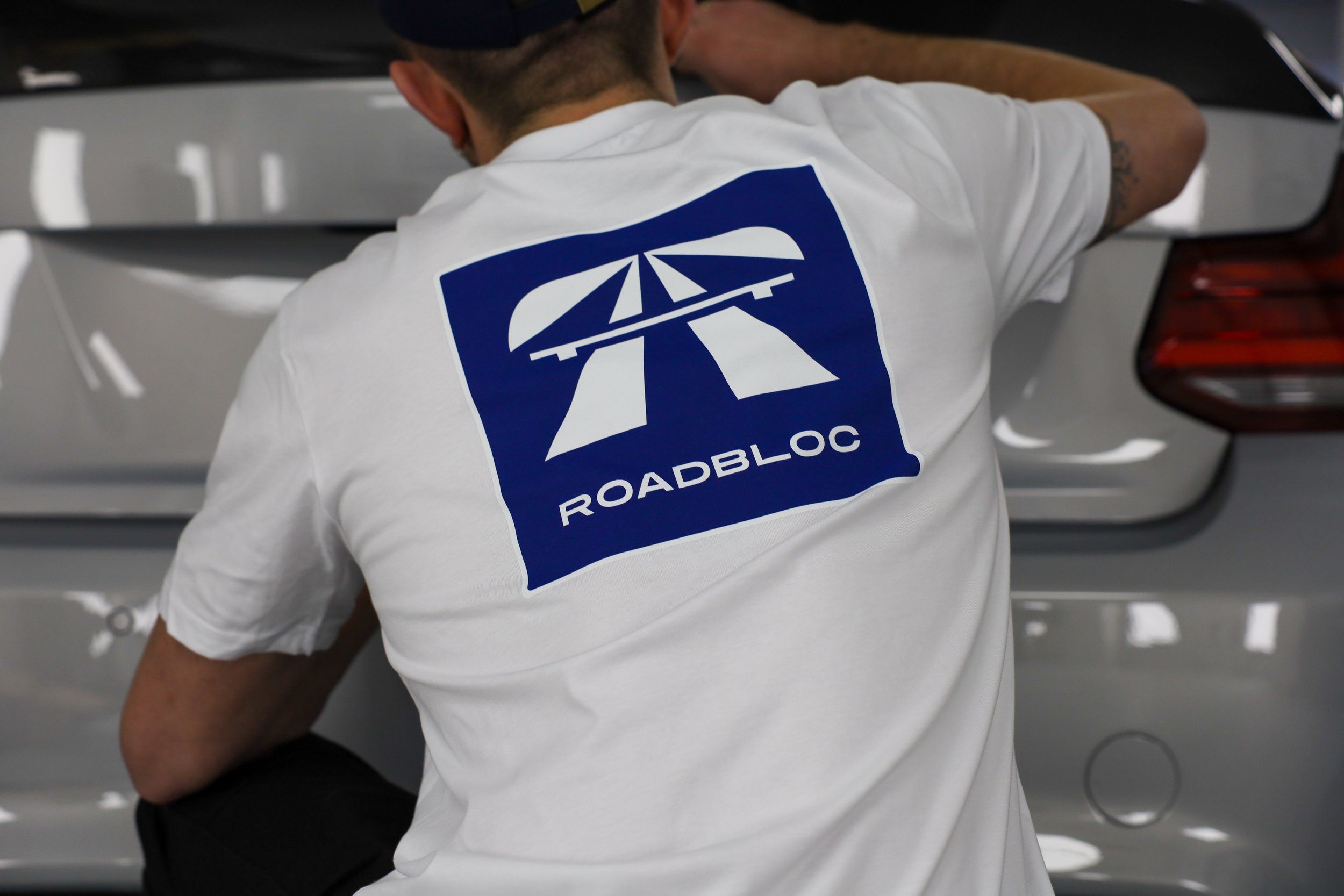 The Autobahn Tee by Roadbloc, white with the blue road sign graphic