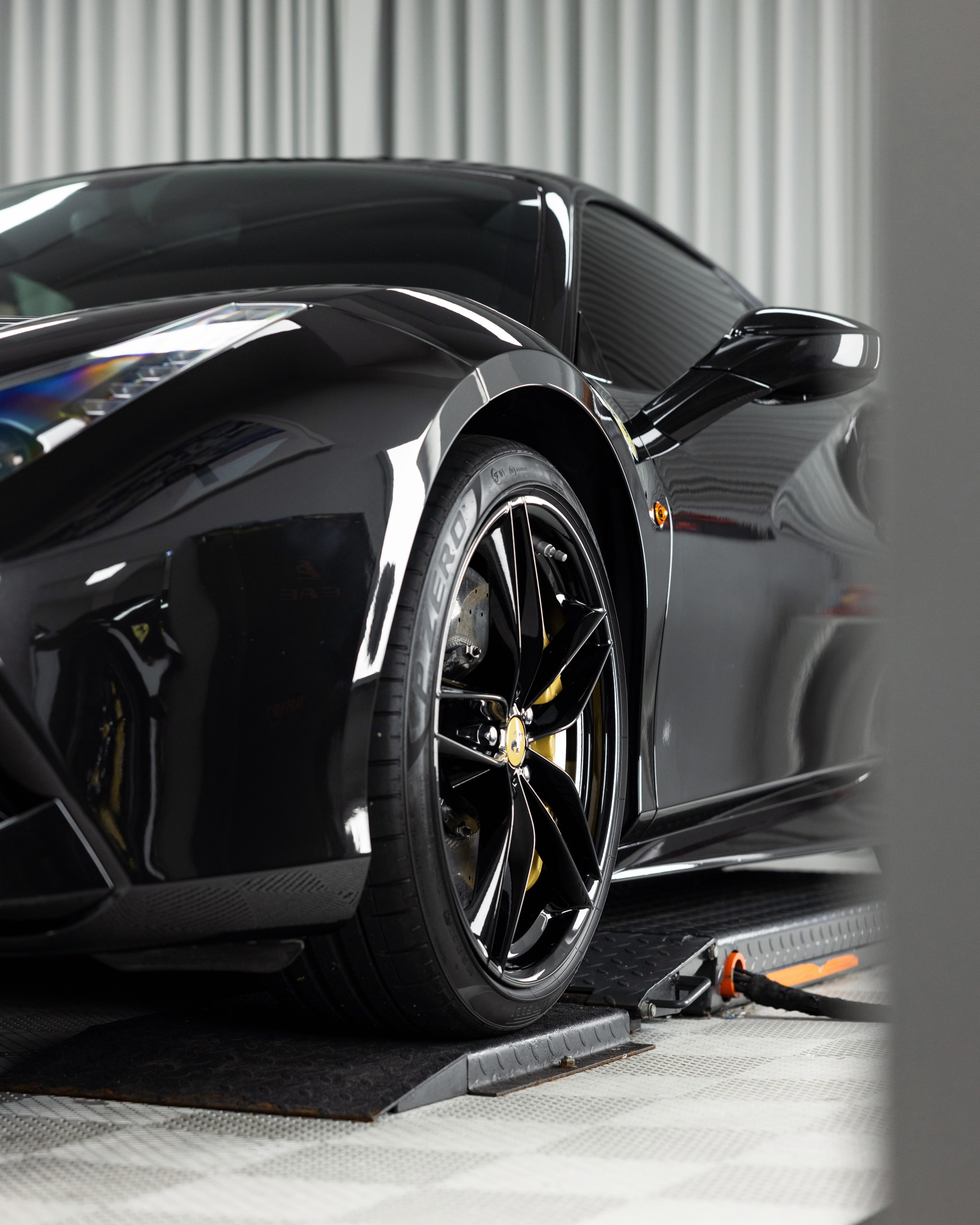 Gloss black Ferrari, side on, after coating in the Roadbloc studio