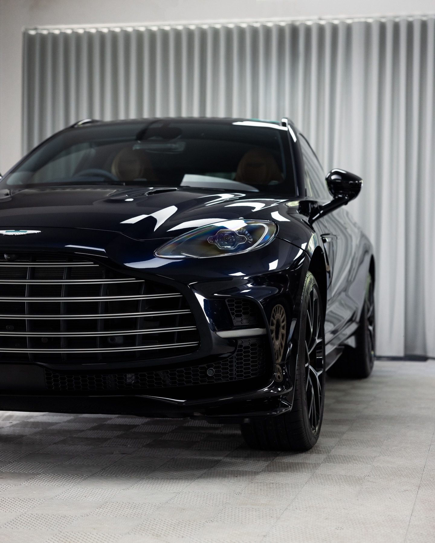 Dark blue Aston Martin DBX with tinted windows in the Roadbloc studio