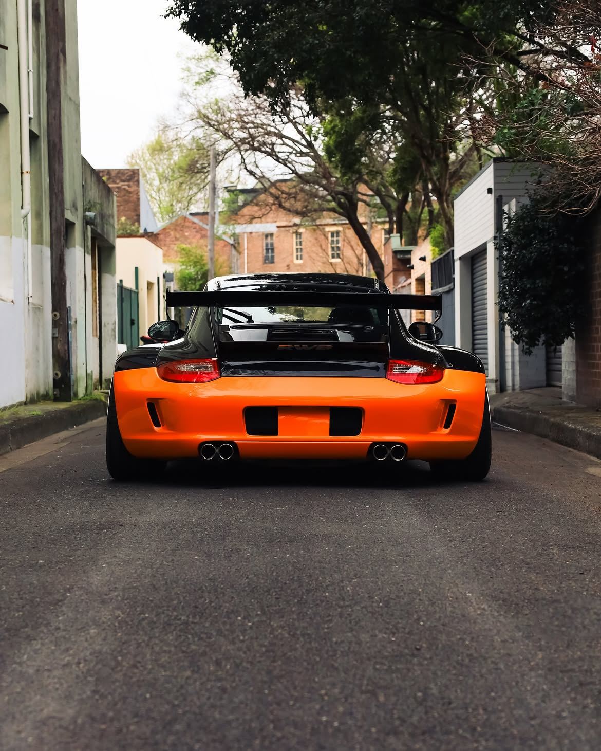 Black RWB widebody Porsche 911 with orange vinyl bumpers, by Roadbloc