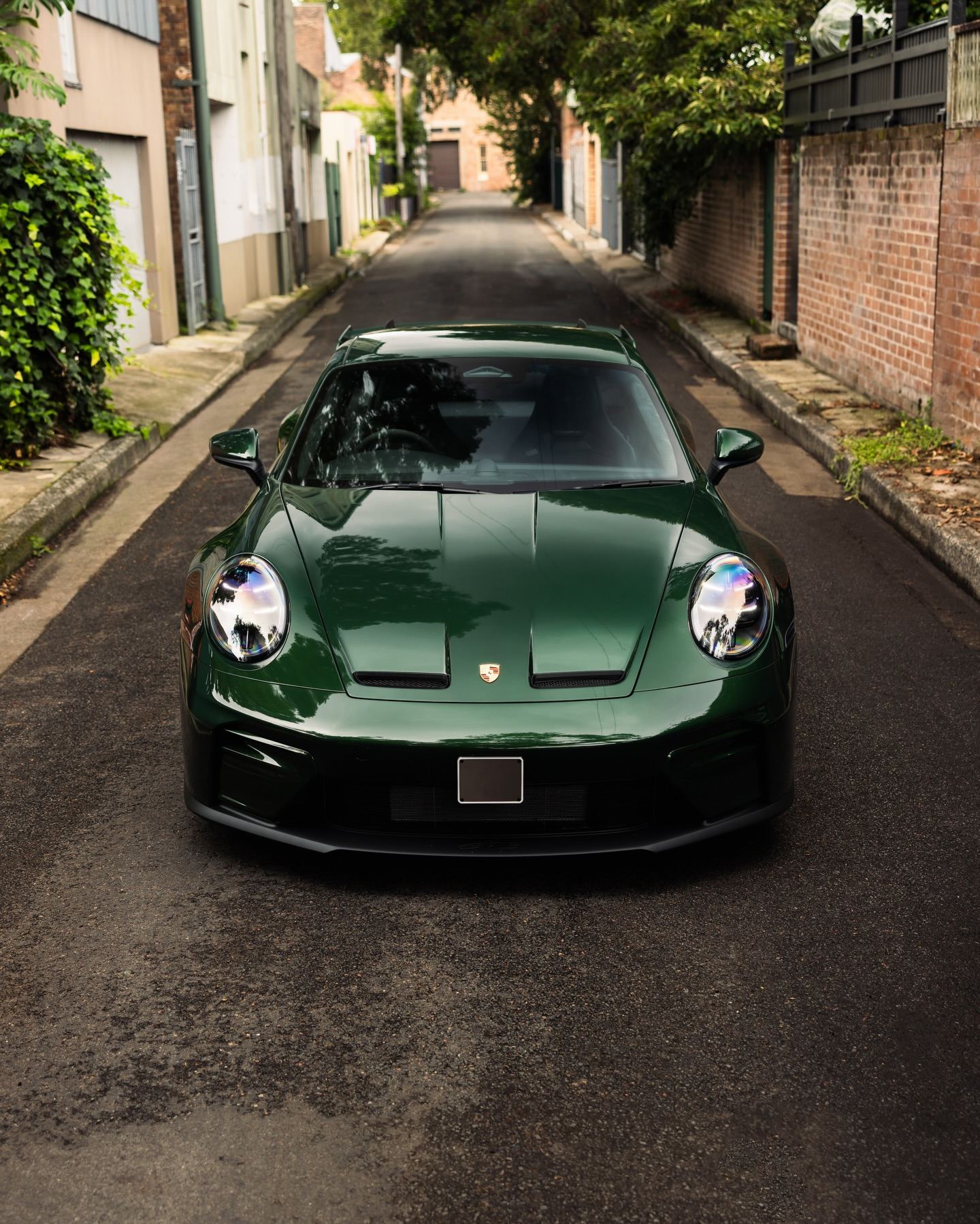Dark green Porsche 911 GT3 head on in a Sydney back lane