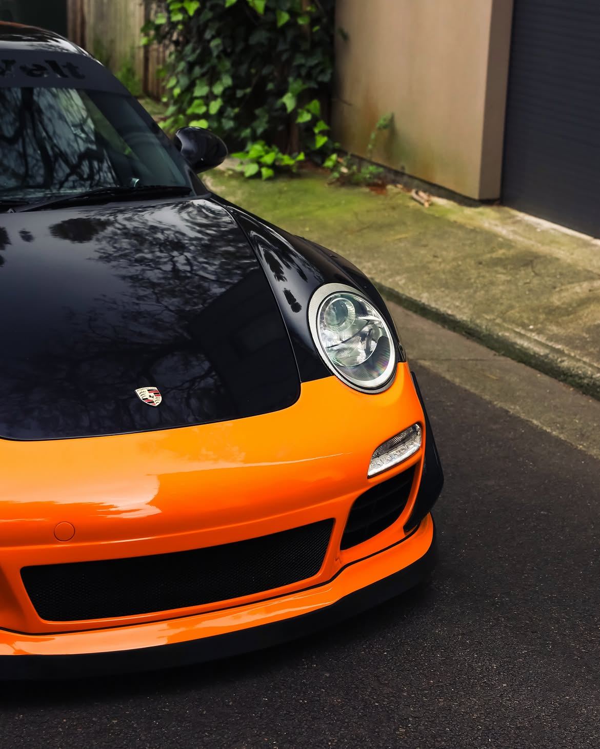 Black RWB widebody Porsche 911 with orange vinyl bumpers, by Roadbloc