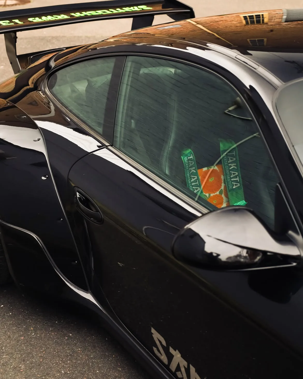 Black RWB widebody Porsche 911 with orange vinyl bumpers, by Roadbloc