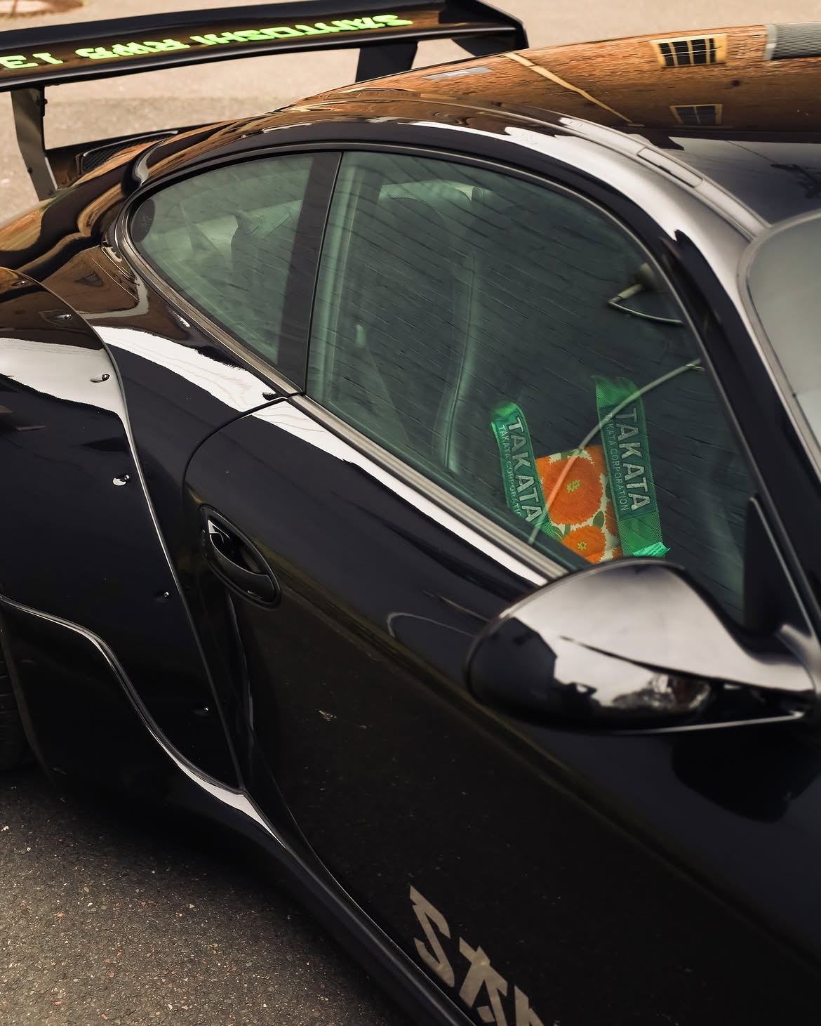 Black RWB widebody Porsche 911 with orange vinyl bumpers, by Roadbloc