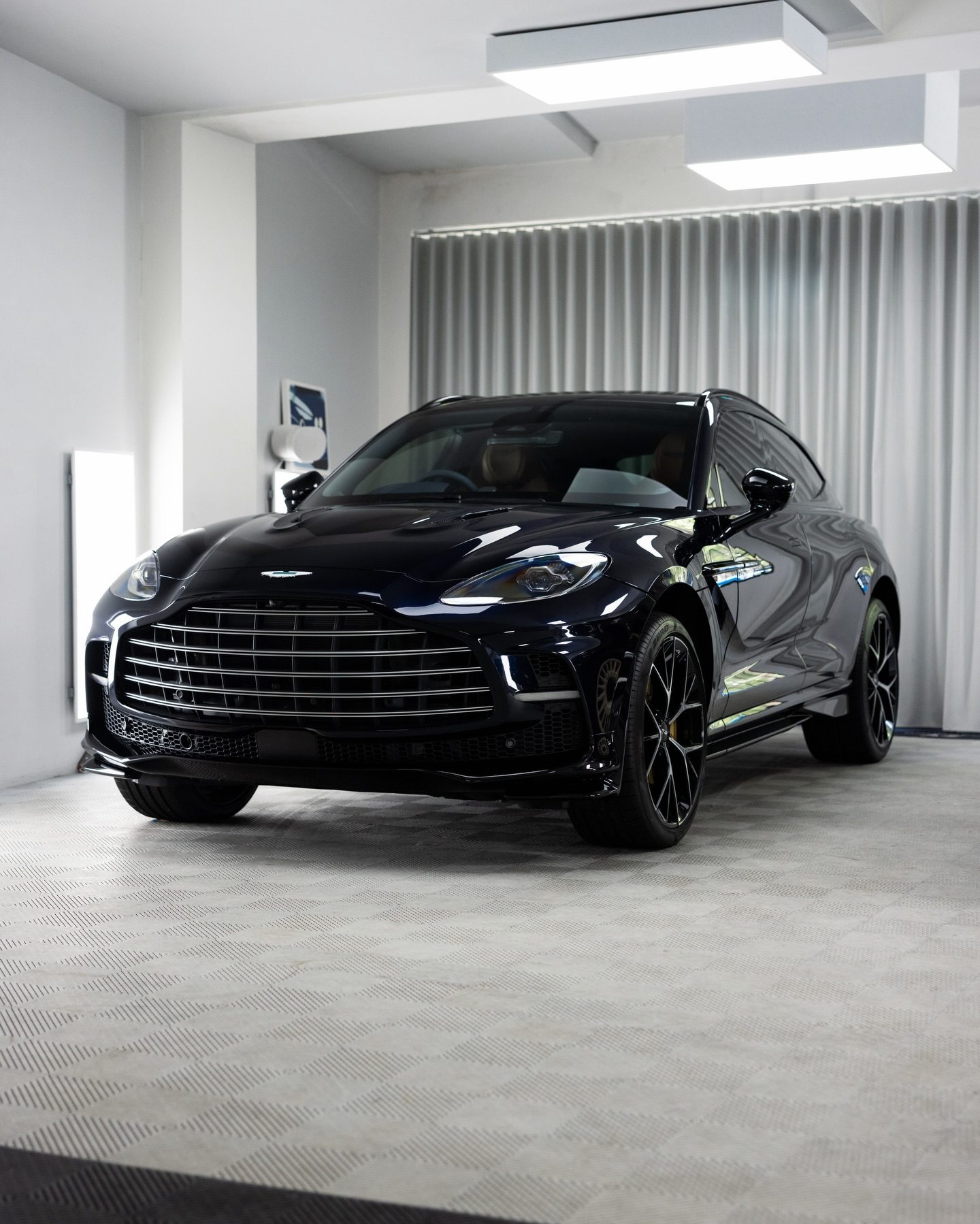 Dark blue Aston Martin DBX head on in the Roadbloc studio